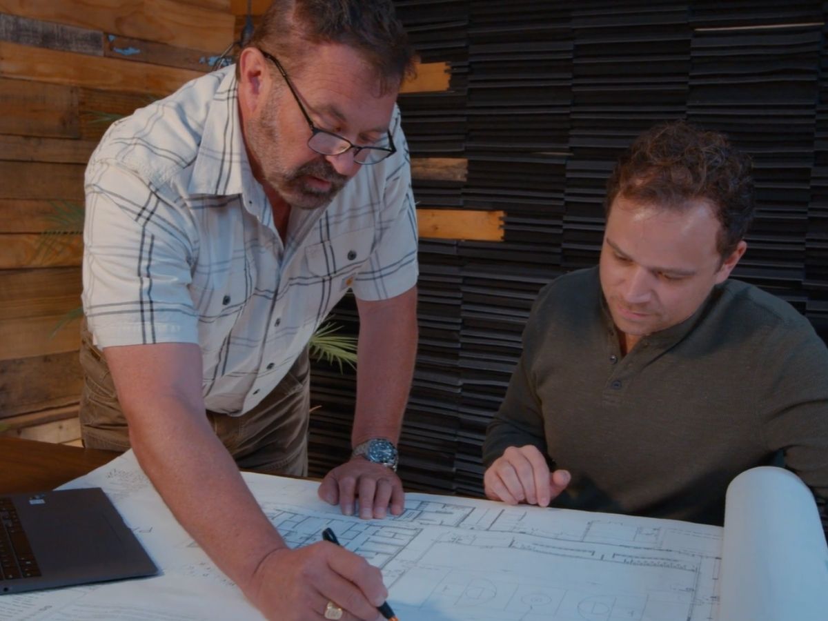 Two engineers reviewing blueprints together